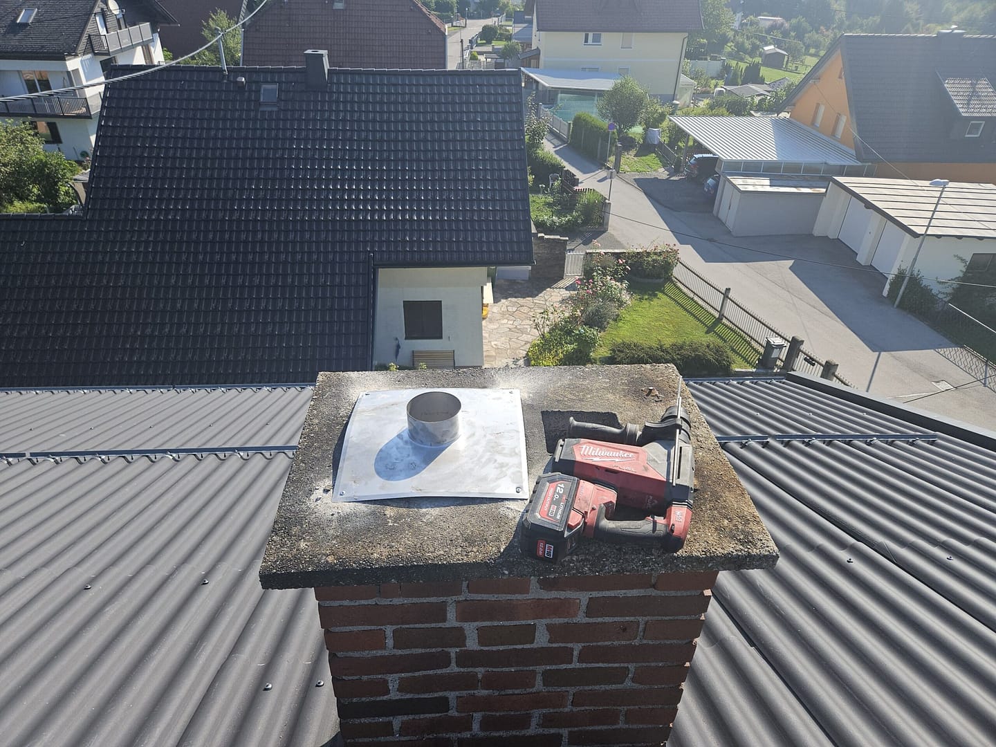 Gemauerter Kamin mit einem rotem Werkzeug darauf.